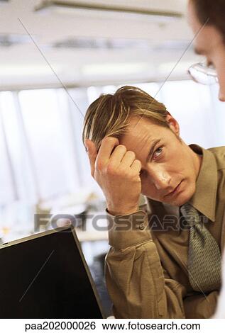 Businessman holding head, looking at second businessman View Large Photo Image Stock Photograph - Businessman holding head, looking at second businessman. Fotosearch
