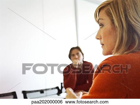 Businessman sitting across from businesswoman, blurred. View Large Photo Image Stock Photograph - Businessman sitting across from businesswoman, blurred.. Fotosearch