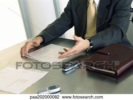 Businessman sitting at table View Large Photo Image Stock Image - Businessman sitting at table. Fotosearch