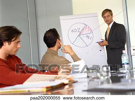 Stock Photography - Businessmen attending presentation. Fotosearch