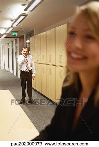 Businesswoman smiling, man on phone in background, blurred. View Large Photo Image Stock Image - Businesswoman smiling, man on phone in background, blurred. . Fotosearch