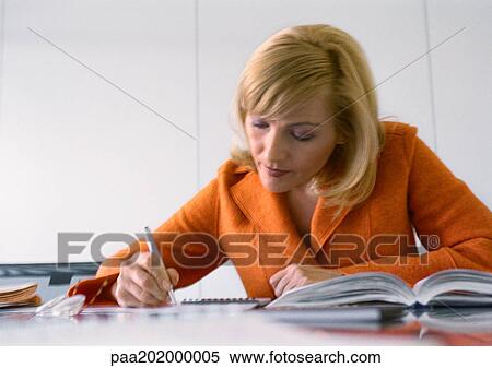 Stock Photography - Businesswoman working at desk.. Fotosearch