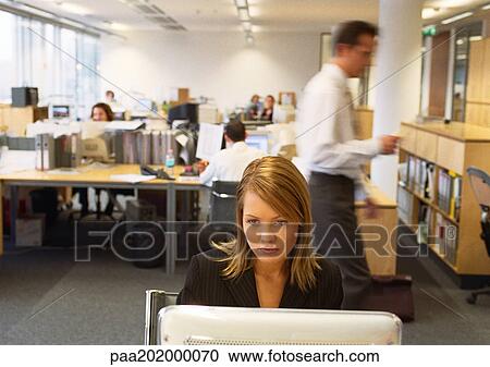 Businesswoman working on computer, business people working in background. View Large Photo Image Stock Image - Businesswoman working on computer, business people working in background.. Fotosearch