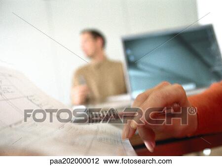 Woman's hand holding pen over agenda, man blurred in background View Large Photo Image Stock Image - Woman's hand holding pen over agenda, man blurred in background. Fotosearch