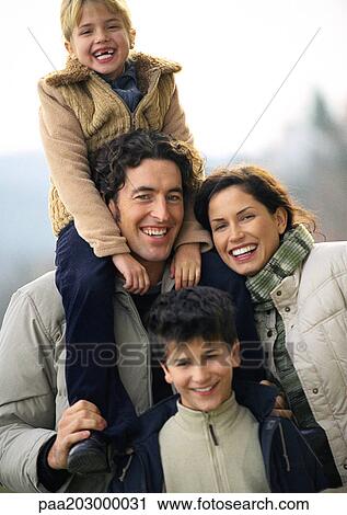 Adult man and woman standing with two children, little girl on man's shoulders, little boy standing in front, portrait View Large Photo Image Stock Image - Adult man and woman standing with two children, little girl on man's shoulders, little boy standing in front, portrait. Fotosearch