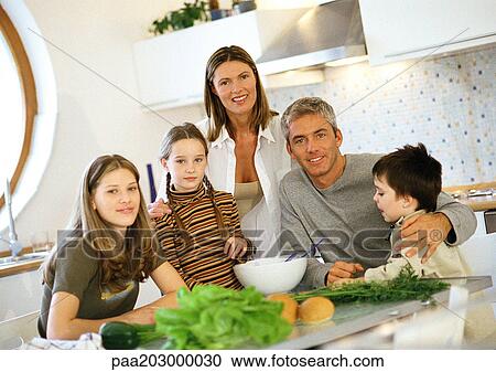 Stock Image - Family in kitchen, portrait.. Fotosearch