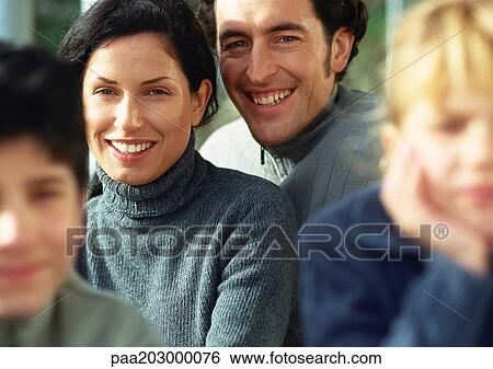 Stock Photograph - Family in warm clothes, portrait, children blurred in foreground, close up.. Fotosearch