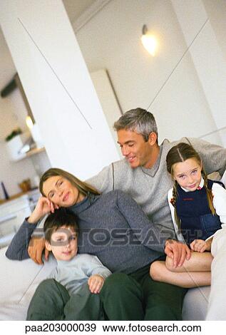 Family sitting on couch in living room, portrait. View Large Photo Image Stock Photo - Family sitting on couch in living room, portrait.. Fotosearch