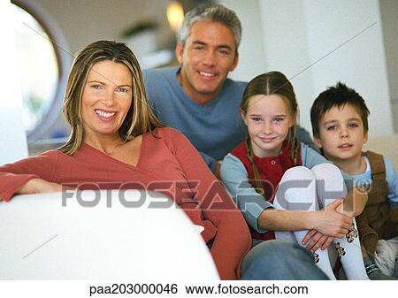 Stock Photograph - Family sitting together on couch, portrait.. Fotosearch