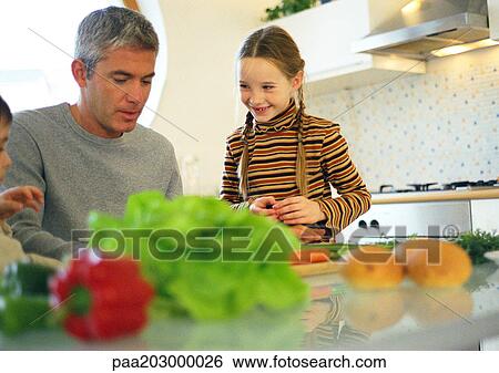 Stock Photograph - Father and daughter in kitchen.. Fotosearch