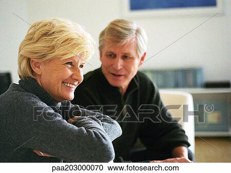 Senior woman sitting with arms folded across chest, side view, senior man in background, looking at woman, head and shoulders View Large Photo Image Stock Image - Senior woman sitting with arms folded across chest, side view, senior man in background, looking at woman, head and shoulders. Fotosearch