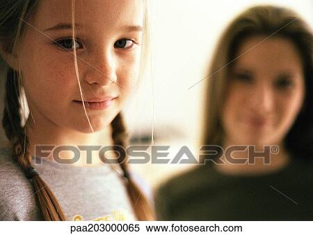 Two girls, little girl in foreground, older girl blurred in background, portrait. View Large Photo Image Stock Photography - Two girls, little girl in foreground, older girl blurred in background, portrait.. Fotosearch