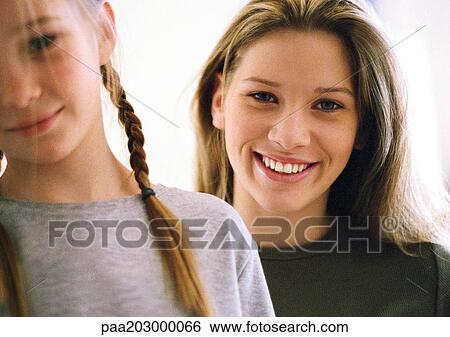 Stock Photograph - Two girls, one blurred in foreground, portrait.. Fotosearch
