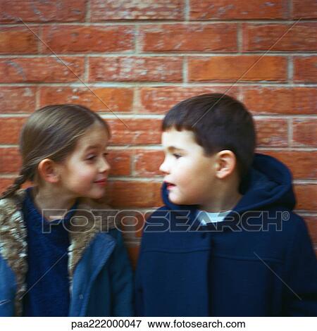 Boy and girl standing in front of brick wall, blurred View Large Photo Image Stock Photo - Boy and girl standing in front of brick wall, blurred. Fotosearch