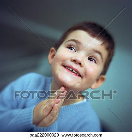 Boy smiling, looking to the side with hands together, portrait View Large Photo Image Stock Photo - Boy smiling, looking to the side with hands together, portrait. Fotosearch