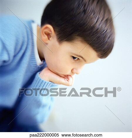 Stock Photography - Boy with hand under chin, side view. Fotosearch