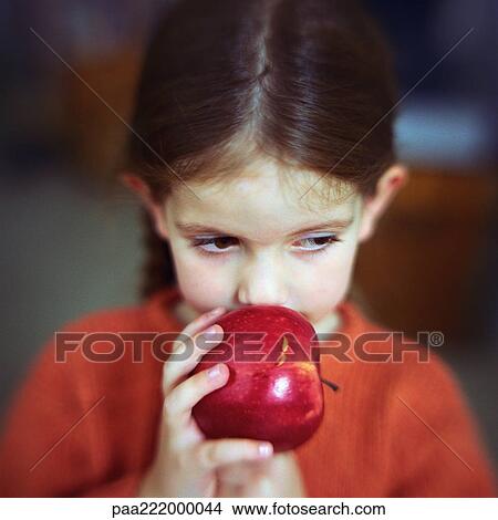 Girl smelling apple, portrait View Large Photo Image Picture - Girl smelling apple, portrait. Fotosearch