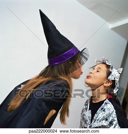 Two girls wearing costumes, sticking out tongues at each other View Large Photo Image Picture - Two girls wearing costumes, sticking out tongues at each other. Fotosearch