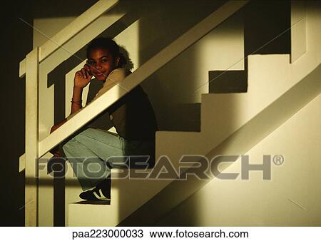Young boy sitting on stairs, taklking on phone, smiling. View Large Photo Image Stock Image - Young boy sitting on stairs, taklking on phone, smiling.. Fotosearch