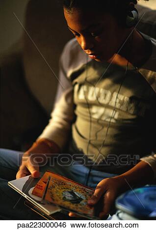 Young boy with headphones on looking at CDs View Large Photo Image Stock Photograph - Young boy with headphones on looking at CDs. Fotosearch