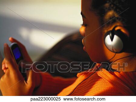 Young boy with headphones on looking at phone, close up. View Large Photo Image Stock Photography - Young boy with headphones on looking at phone, close up.. Fotosearch