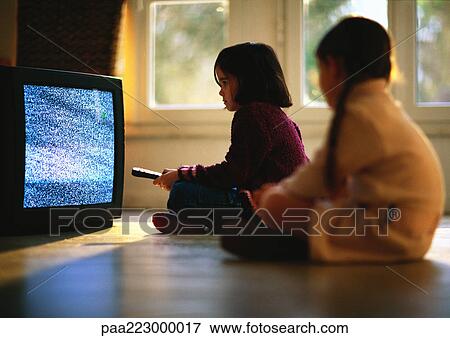 Young girls sitting on wood floor watching TV, girl in foreground blurred. View Large Photo Image Stock Photo - Young girls sitting on wood floor watching TV, girl in foreground blurred.. Fotosearch