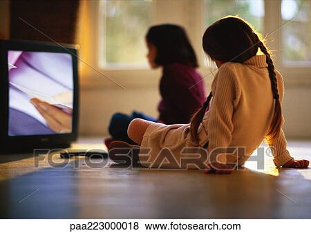 Young girls sitting on wood floor watching TV, girl in background blurred. View Large Photo Image Stock Photo - Young girls sitting on wood floor watching TV, girl in background blurred.. Fotosearch