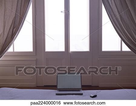 Laptop in front of door on bed View Large Photo Image Stock Photograph - Laptop in front of door on bed. Fotosearch