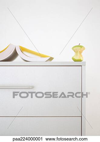 Open book and apple core on top of dresser. View Large Photo Image Stock Image - Open book and apple core on top of dresser.. Fotosearch
