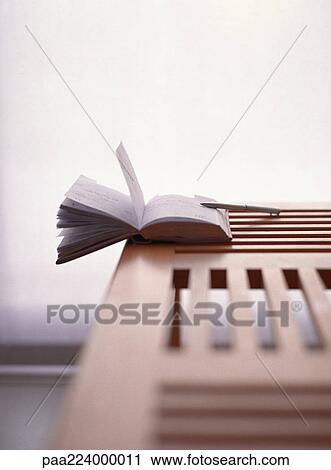 Open book hanging off wooden table View Large Photo Image Stock Image - Open book hanging off wooden table. Fotosearch