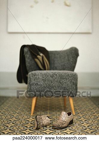 Pair of shoes in front of chair with jacket draped over back. View Large Photo Image Stock Photo - Pair of shoes in front of chair with jacket draped over back.. Fotosearch
