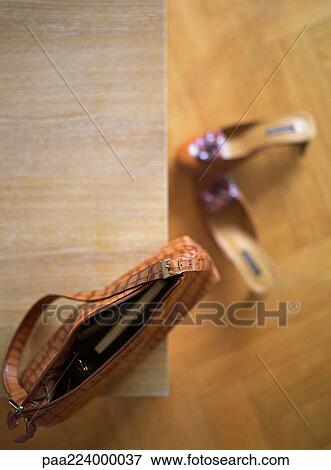Purse on table, shoes on floor, high angle view View Large Photo Image Stock Photo - Purse on table, shoes on floor, high angle view. Fotosearch
