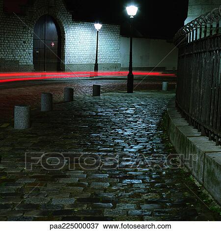 Cobbled street at night and red light trails, long exposure. View Large Photo Image Stock Photo - Cobbled street at night and red light trails, long exposure.. Fotosearch