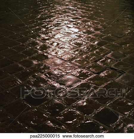 Stock Photography - Light reflected onto cobbles, night.. Fotosearch