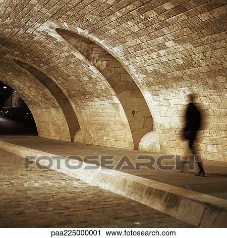 Person walking under tunnel at night View Large Photo Image Stock Image - Person walking under tunnel at night. Fotosearch