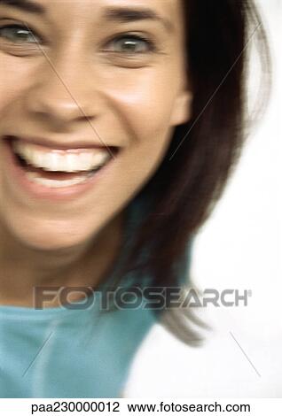 Stock Image - Woman smiling at camera, close up, blurred portrait.. Fotosearch