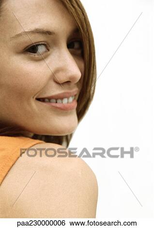 Woman smiling at camera over shoulder, close up portrait. View Large Photo Image Stock Photograph - Woman smiling at camera over shoulder, close up portrait.. Fotosearch