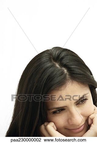Stock Image - Woman tilting head, chin in hands, portrait. Fotosearch