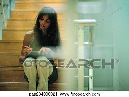 Woman sitting on stairs writing. View Large Photo Image Stock Image - Woman sitting on stairs writing.. Fotosearch