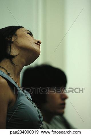 Woman tilting head, next to man, side view View Large Photo Image Stock Photo - Woman tilting head, next to man, side view. Fotosearch
