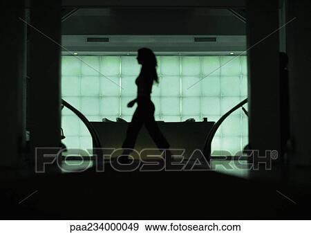 Woman walking in front of desk, silhouette, view through doorway. View Large Photo Image Stock Photo - Woman walking in front of desk, silhouette, view through doorway.. Fotosearch