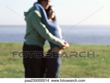 Man and woman hugging by water. View Large Photo Image Picture - Man and woman hugging by water.. Fotosearch