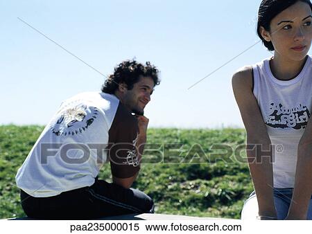 Man and woman sitting in grass facing different directions. View Large Photo Image Stock Photography - Man and woman sitting in grass facing different directions.. Fotosearch
