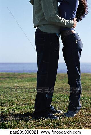 Man and woman standing facing each other on grass by water, lower section View Large Photo Image Stock Image - Man and woman standing facing each other on grass by water, lower section. Fotosearch