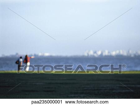 Two people standing together by ocean, blurred. View Large Photo Image Stock Image - Two people standing together by ocean, blurred.. Fotosearch