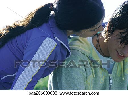 Stock Photo - Woman leaning over man's shoulder, close up.. Fotosearch