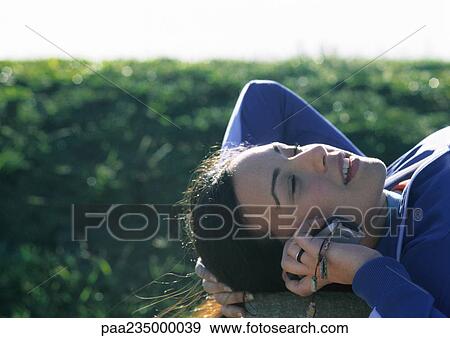 Woman lying on grass talking on phone. View Large Photo Image Stock Photo - Woman lying on grass talking on phone.. Fotosearch