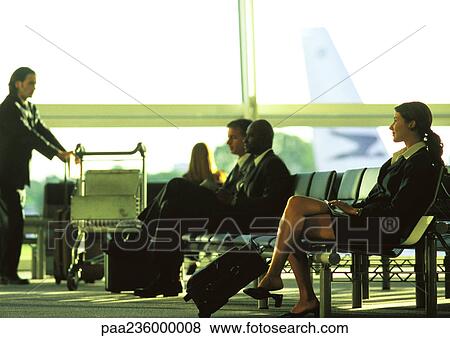 Stock Photo - Business people in suits waiting in airport terminal. Fotosearch