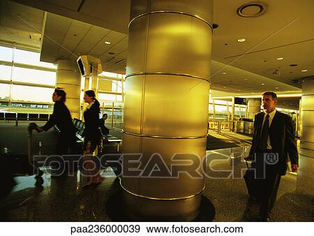 Stock Photo - Business people walking in airport terminal.. Fotosearch