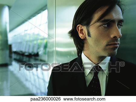 Businessman next to metallic wall looking to the side, close up. View Large Photo Image Stock Photograph - Businessman next to metallic wall looking to the side, close up.. Fotosearch